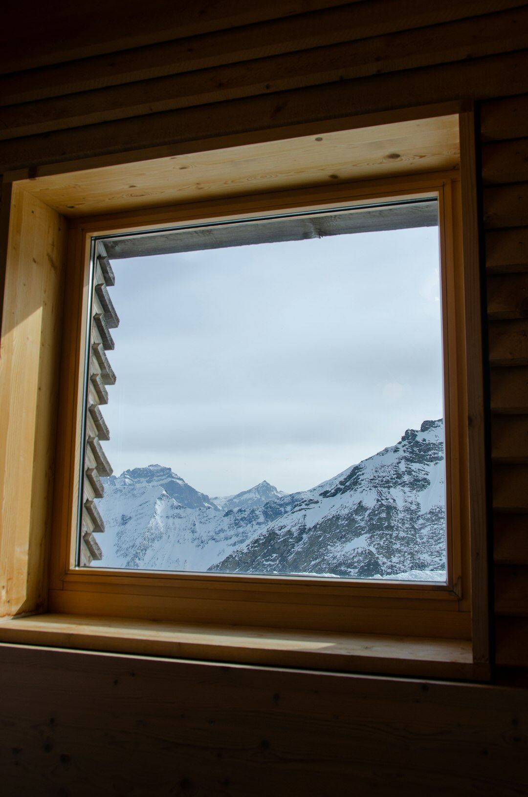 Small modern editorial office in Switzerland with the Alps visible through the window